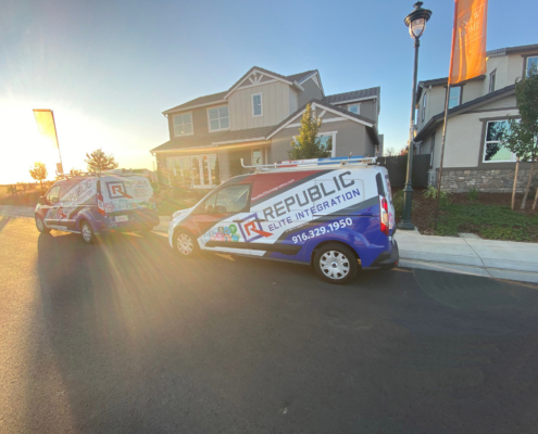 Republic Elite Integration Installation REI Vans in front of model home with sunrise behind them