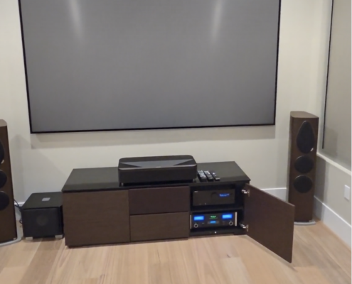 Completed home theater featuring McIntosh audio equipment, floor-standing speakers, and a large projection screen.
